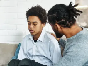 家長與青少年坐在家中交談，傾聽孩子的想法與困難。